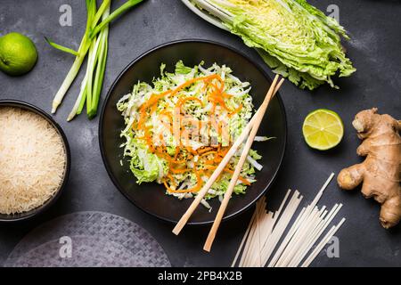 Vietnamesischer Salat. Frische Zutaten für die Zubereitung des vietnamesischen Abendessens: Reispapier, Reis, Nudeln, grüne Zwiebel, napakohl, Salat. Asiatische Kochzutat Stockfoto