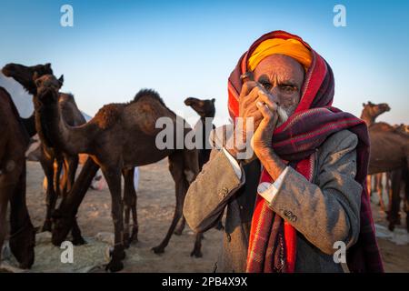 Ältere Rajasthani Mann mit einem Turban Rauchen ein Hash pipe, Pushkar, Rajasthan, Indien Stockfoto