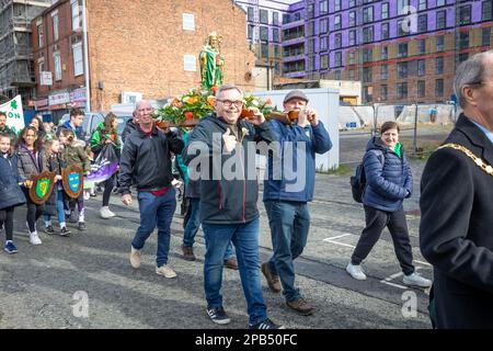 Warrington, Cheshire, Großbritannien - 12. März 2023 – Warrington Irish Club ist Gastgeber des St. Patrick's Day Parade. Beginn um 10,30 Uhr morgens vom Irish Club in der Orford Lane zum „River of Life“ in der Bridge Street im Stadtzentrum, wo ein kurzer Gottesdienst zum Gedenken an den Jahrestag des Bombenanschlags in Warrington abgehalten wurde. Die Statuen tragende Prozession führt durch das Stadtzentrum. Kredit: John Hopkins/Alamy Live News Stockfoto