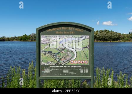 Henley Lake Park in Masterton, Neuseeland, an einem hellen Sommertag. Schild mit Wanderrouten und Karte Stockfoto