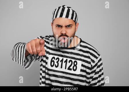 Emotionaler Gefangener in Spezialuniform auf grauem Hintergrund Stockfoto