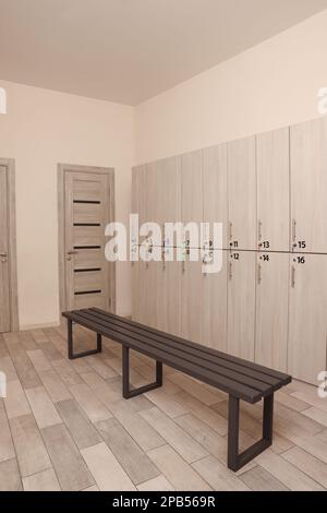 Holzbank und Schließfächer im Umkleideraum Stockfoto