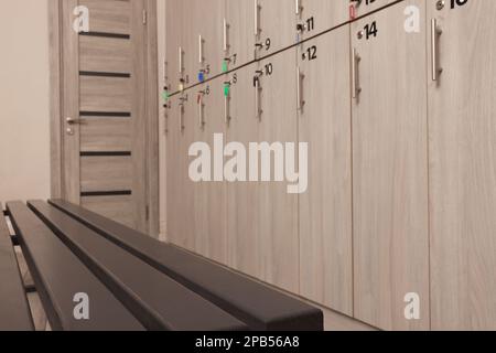 Holzbank in der Nähe der Schließfächer im Umkleideraum Stockfoto