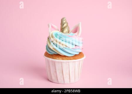 Süßer süßer Einhorn-Cupcake auf pinkfarbenem Hintergrund Stockfoto