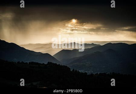Banner von Berggipfeln in herrlichem stürmischen Sonnenuntergang Stockfoto