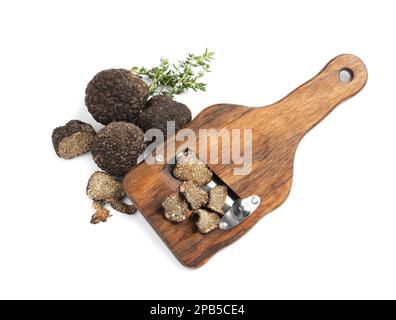 Holzmesser mit schwarzen Trüffeln und Thymian auf weißem Hintergrund, Draufsicht Stockfoto