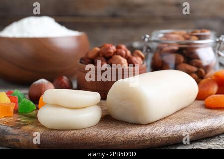 Marzipan und andere Zutaten für hausgemachtes Stollen auf Holztisch, Nahaufnahme. Traditionelles deutsches Weihnachtsbrot backen Stockfoto