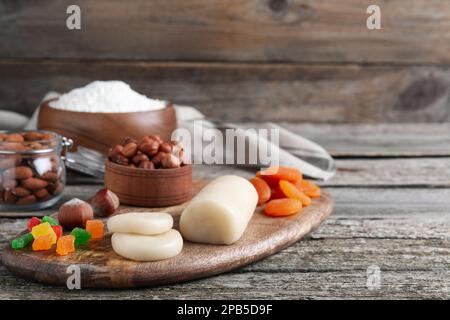 Marzipan und andere Zutaten für hausgemachtes Stollen auf einem Holztisch. Traditionelles deutsches Weihnachtsbrot backen Stockfoto