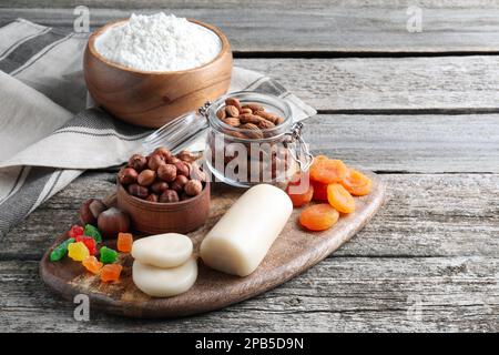 Marzipan und andere Zutaten für hausgemachtes Stollen auf einem Holztisch. Traditionelles deutsches Weihnachtsbrot backen Stockfoto