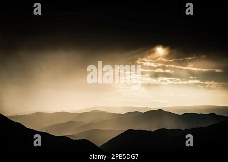 Banner von Berggipfeln in herrlichem stürmischen Sonnenuntergang Stockfoto