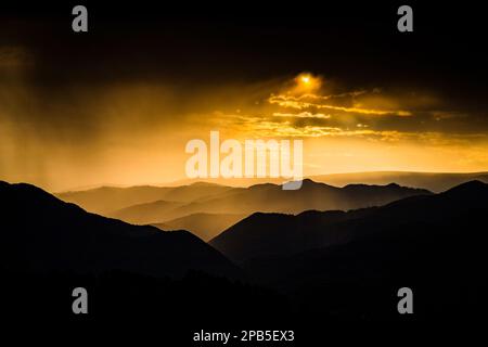 Banner von Berggipfeln in herrlichem stürmischen Sonnenuntergang Stockfoto