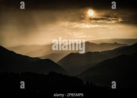 Banner von Berggipfeln in herrlichem stürmischen Sonnenuntergang Stockfoto