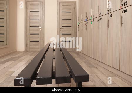 Holzbank in der Nähe der Schließfächer im Umkleideraum Stockfoto