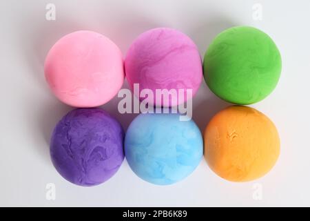 Die Knetkugeln spielen in verschiedenen Farben auf weißem Hintergrund, Draufsicht Stockfoto