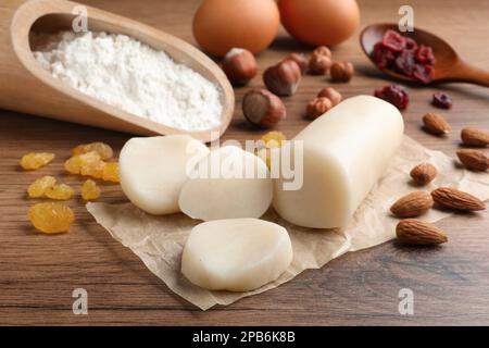 Marzipan und andere Zutaten für hausgemachtes Stollen auf einem Holztisch. Traditionelles deutsches Weihnachtsbrot backen Stockfoto