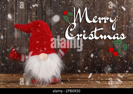 Frohe Weihnachten! Süßer Zwerg auf Holztisch Stockfoto