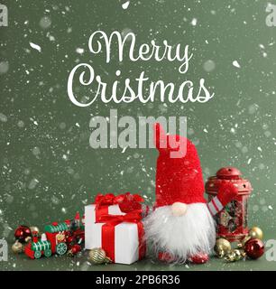 Frohe Weihnachten! Süßer Zwerg, Geschenkboxen und festliche Einrichtung auf grünem Hintergrund Stockfoto