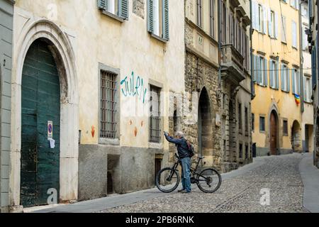 BERGAMO, ITALIEN - APRIL 2022: Schmale mittelalterliche Straße der Stadt Bergamo nordöstlich von Mailand. Malerische Aussicht auf Citta Alta, das obere Viertel der Stadt, umgeben von B Stockfoto