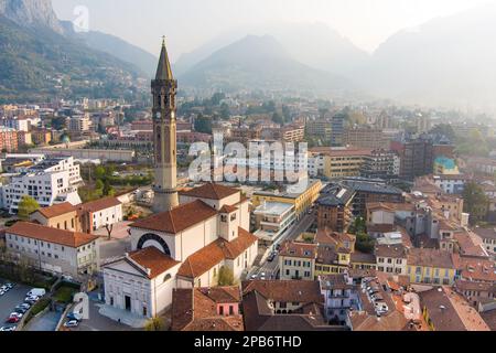 Neblige Sonnenaufgang-Stadtlandschaft von Lecco am Frühlingstag. Malerische Uferpromenade der Stadt Lecco zwischen dem berühmten Comer See und dem malerischen Bergamo A. Stockfoto