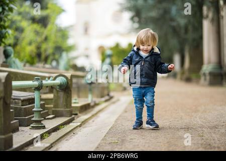 Ein kleiner Junge besucht das Cimitero Monumentale di Milano oder den monumentalen Friedhof von Mailand, einen der beiden größten Friedhöfe in Mailand, bekannt für die Stockfoto