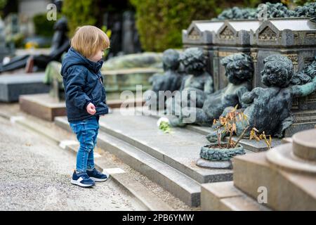 Ein kleiner Junge besucht das Cimitero Monumentale di Milano oder den monumentalen Friedhof von Mailand, einen der beiden größten Friedhöfe in Mailand, bekannt für die Stockfoto