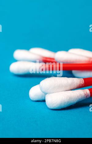 Ein Haufen roter Wattestäbchen auf blauem Hintergrund, Nahaufnahme, Kopierbereich Stockfoto