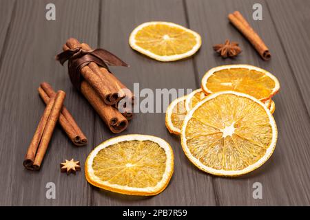 Zimtstäbchen und trockene orangefarbene Scheiben auf Holzhintergrund. Draufsicht. Stockfoto