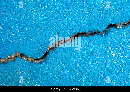 Riss an der blauen Betonoberfläche. Bremse, kaputtes Konzept Stockfoto