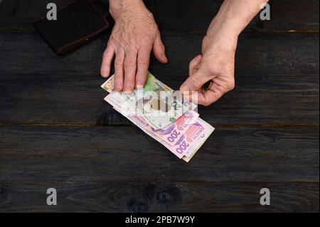 Geld in den Händen einer älteren Frau aus der Nahaufnahme. Stockfoto