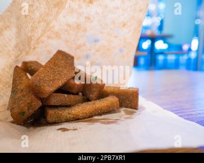 Toasterd Knoblauch-Roggen-Croutons im Geschenkpapier, Street Food Stockfoto