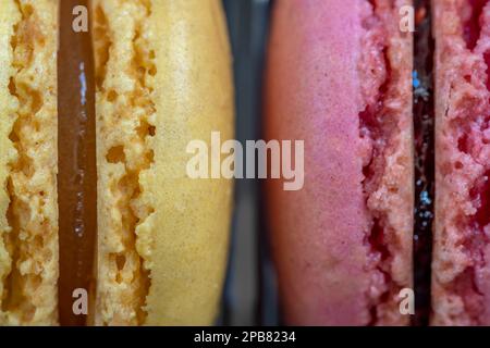 Nahaufnahme von gelben und pinkfarbenen gefüllten Makronen Stockfoto