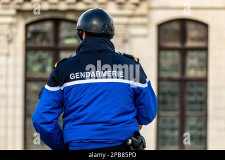 Chambord, Frankreich. 25. Februar 2023. Französischer Gendarm auf einem Pferd, von hinten gesehen, mit Inschrift Gendarme auf seiner Jacke Stockfoto