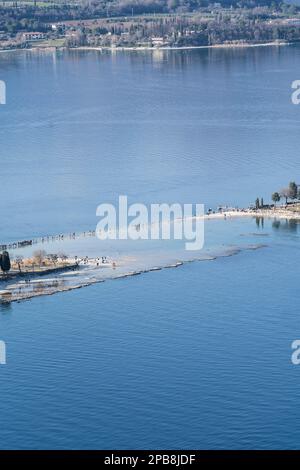 12. März 2023: Manerba del Garda, Brescia, Italien 12. März, Dürre in norditalien Menschen gehen von Punta Belvedere nach Isola dei Conigli in einem Teil des Gardasees, der aufgrund der schweren Dürre ungewöhnlich trocken ist (Bild: © Matteo Biatta/ZUMA Press Wire) REDAKTIONELLE VERWENDUNG! Nicht für den kommerziellen GEBRAUCH! Stockfoto