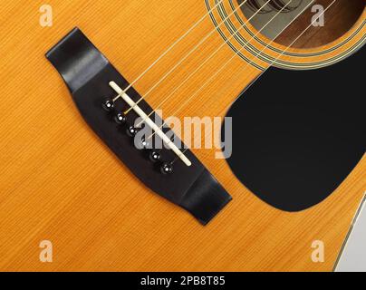 Musikinstrument - Fragment Draufsicht Schlagbrett, Brücke, Stifte und Streichern vintage Akustik Gitarre. Stockfoto