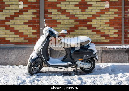 Schneebedeckte Vespa vor der Kulisse der Markthalle Vanha Kauppahalli in Helsinki, Finnland Stockfoto