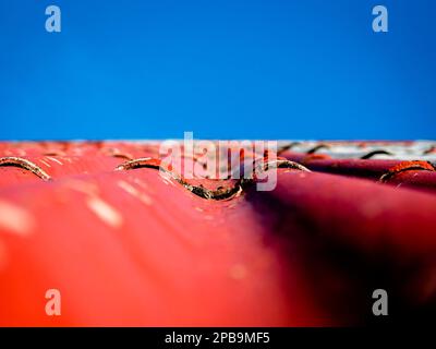 Alte Dachkippen in Rot mit blauem Himmel Stockfoto