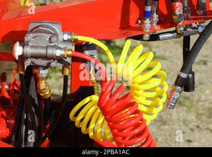 Rote und gelbe Druckluftröhren und das oleodynamische System einer Industriemaschine im Werk Stockfoto