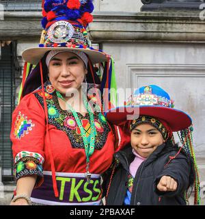 London, Großbritannien. 12. März 2023. Eine Frau und ein Kind aus einer bolivianischen Tanzgruppe wärmen sich vor Beginn der Parade auf. Die jährlich stattfindende St. Patrick's Day Parade führt durch das Zentrum von London, um die irische Gemeinde und irische Kultur und das irische Erbe mit Teilnehmern in Kostümen, Marschkapellen, Pracht und vielem mehr zu feiern, die von Zuschauern entlang der Strecke beobachtet werden. Kredit: Imageplotter/Alamy Live News Stockfoto