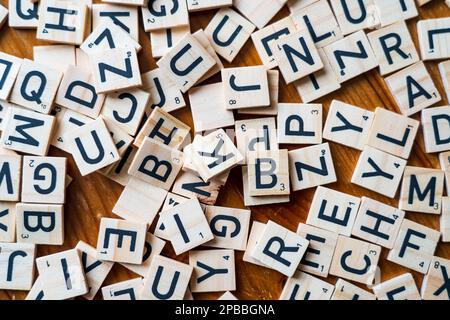 Auf dem Tisch verstreute Buchstabensteine aus Holz Stockfoto