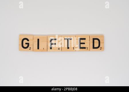 Holztitel, der das Wort begabt buchstabiert, isoliert auf weißem Hintergrund Stockfoto