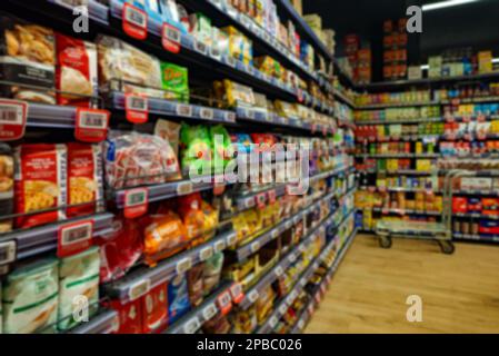 Verschwommenes Bild von Regalen mit Snacks im Supermarkt. Stockfoto