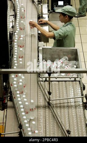 A worker selects water bottles at the production line of Wahaha Tuesday ...