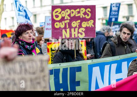 Weibliche Demonstranten mit Protestbanner auf NHS-Demonstration durch Central London zur Downing Street, Samstag, 11. März 2023, England, Großbritannien. Stockfoto