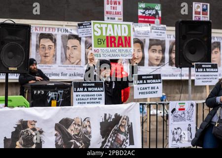 Frau hält während der Proteste in London am 2023. März das Protestplakat "Stand by Iran" gegen das iranische Regime in Händen. Stockfoto