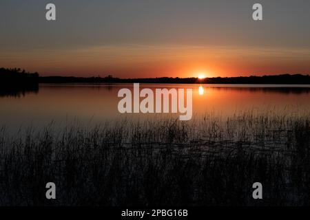 Wunderschöner Sonnenuntergang auf dem nördlichen See mit Reflexion Stockfoto