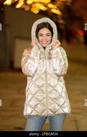 Frau in Winterjacke, die in die Kamera schaut und im Freien lächelt. Wintersaison Konzept. Stockfoto