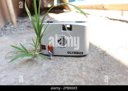 Miniaturfigur eines Großvaters, der vor dem Haus wartet. Stockfoto