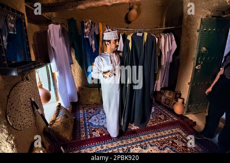 Ein Mann in traditionellem Dishdasha-Bademantel, Bait al Safah, Al Hamra, Oman Stockfoto