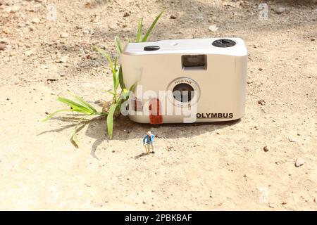 Miniaturfigur eines Großvaters, der vor dem Haus wartet. Stockfoto