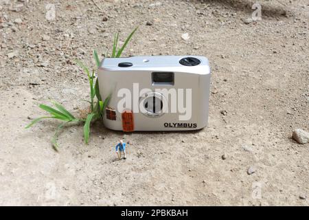 Miniaturfigur eines Großvaters, der vor dem Haus wartet. Stockfoto